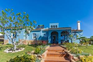 una casa azul con un camino en un jardín en Chalet Azul, en Aljaraque