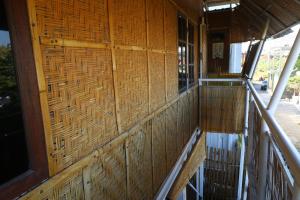 a building with a wicker wall and a balcony at Kris Kos in Canggu