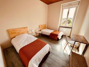- une chambre avec 2 lits et une fenêtre dans l'établissement Au Bonheur Arédien, à Saint-Yrieix-la-Perche