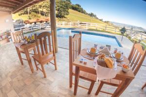 einen Esstisch und Stühle neben einem Pool in der Unterkunft Pousada Sonho Meu in Camanducaia