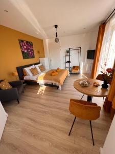 フラウウェンポルデルにあるEtoile aan Zeeのベッドルーム1室(ベッド1台、テーブル、ソファ付)