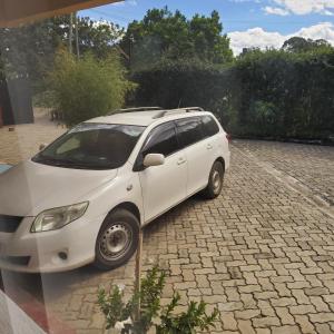 a white car parked in a parking lot at Monrovia Guest House in Nakuru