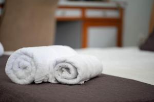 un asciugamano bianco arrotolato, poggiato sopra un letto di Art of urban hospitality! a Mytilini