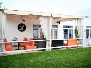 a covered patio with orange chairs and a table at EUROLINE HOTEL ODESSA in Odesa