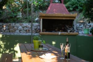 a wooden table with a bottle of wine and two glasses at Studios Kofos Limin in Porto Koufo