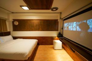 a bedroom with a bed and a large projection screen at Vintage54 Hotel Ayutthaya in Phra Nakhon Si Ayutthaya