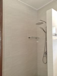 y baño con ducha con cabezal de ducha. en Le Nid de Bea Self-catering Apartments en La Digue