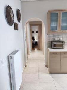 a kitchen with a hallway leading to a living room at A&J Apartments or Rooms athens airport in Markopoulo
