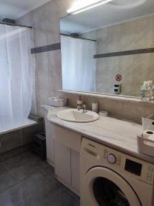 a bathroom with a washing machine and a sink at A&J Apartments or Rooms athens airport in Markopoulo