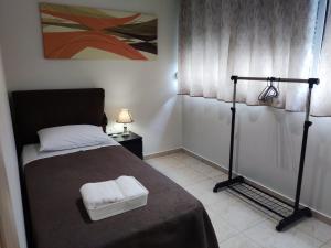 マルコポウロンにあるA&J Apartments or Rooms athens airportのベッドルーム1室(ベッド1台、タオル2枚付)
