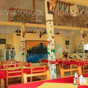 un comedor con mesas y sillas y una habitación con aamed en Talbiun Lodge en Hujirt