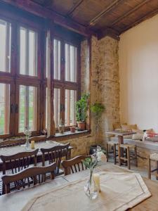 uma sala de jantar com mesas, cadeiras e janelas em Meymune Valide Konağı em Safranbolu