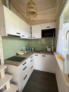 a kitchen with white cabinets and a sink at Przystanek Prawdowo in Mikołajki