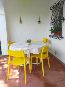 una mesa de comedor amarilla y sillas con una planta en stella marina, en Porto Recanati