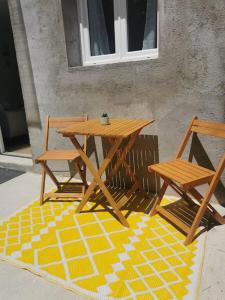 a wooden picnic table and two chairs on a rug at Appartement de 30m2 pour 2 personnes Venaco in Venaco