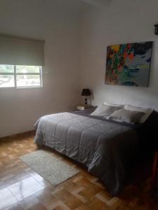 a bedroom with a bed with a painting on the wall at San Cayetano in San Salvador de Jujuy