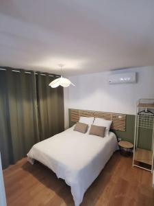 Schlafzimmer mit einem großen weißen Bett in der Unterkunft Appartement de 30m2 pour 2 personnes Venaco in Venaco