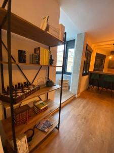 una sala de estar con un estante de libros y un piano en Apartamento en el centro de Benalup-Casas Viejas, en Benalup-Casas Viejas