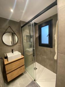 La salle de bains est pourvue d'une douche, d'un lavabo et d'un miroir. dans l'établissement Apartamento en el centro de Benalup-Casas Viejas, à Benalup-Casas Viejas