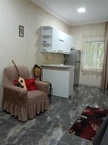 uma sala de estar com uma cadeira e uma cozinha em zaza house em Kutaisi