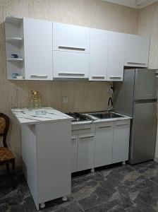 uma cozinha com armários brancos e um frigorífico em zaza house em Kutaisi