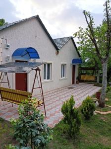 uma casa com um pátio com um guarda-chuva azul em zaza house em Kutaisi