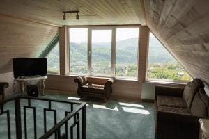 a living room with a large window and a tv at Top House in Yaremche