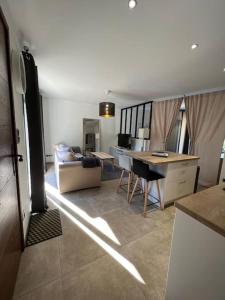 een keuken en woonkamer met een bank en een tafel bij Studio indépendant avec accès piscine in Uzès +2 foto's