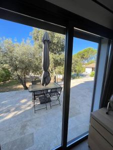 een terras met een parasol en een tafel met een bank bij Studio indépendant avec accès piscine in Uzès