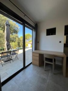 een kamer met een bureau, een tafel en een terras bij Studio indépendant avec accès piscine in Uzès
