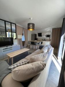 een woonkamer met een bank met kussens erop bij Studio indépendant avec accès piscine in Uzès