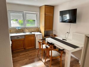 a small kitchen with a white table and chairs at My-Skypalace Neckarsulm in Neckarsulm