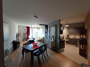 uma sala de estar com uma mesa de jantar e uma cozinha em Coeur Cité Médiévale Appart' 2- 4 personnes "La Salamandre" 80 m2 à 20m de la Mairie em Sarlat-la-Canéda