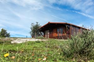 a log cabin on a hill with a grass field at Vila da Laje - Onde a Natureza o envolve - Serra da Estrela in Oliveira do Hospital
