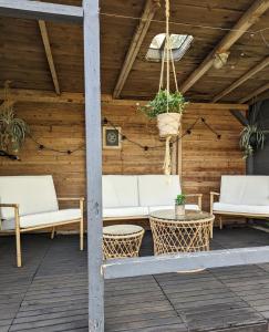 eine Terrasse mit weißen Sofas und einem Tisch in der Unterkunft Ferienhaus Lausitz in Lauta