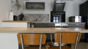 uma cozinha com um balcão de madeira e 2 cadeiras em Maison Centre ville " 100 marches" em Morlaix