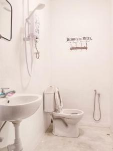La salle de bains blanche est pourvue de toilettes et d'un lavabo. dans l'établissement 246housecafe, à George Town