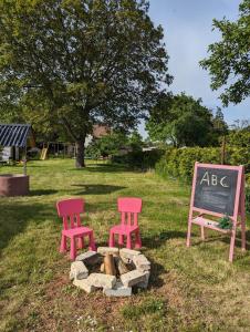two chairs and a sign next to a fire pit at Ferienhaus Lausitz in Lauta