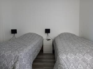 two beds sitting next to each other in a bedroom at Maison ensoleillée et reposante in Le Château-dʼOléron