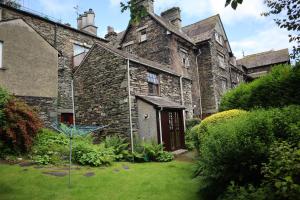 an old stone house with a yard at Clover Cottage - Delightful 1-bed cottage in the heart of Ambleside in Ambleside