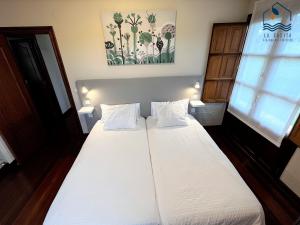 um quarto com uma grande cama branca e 2 almofadas em La Casita Villa Vacacional em Anero