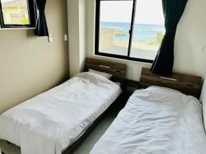 two beds in a room with a view of the ocean at AZ Hotel Ocean View in Sani