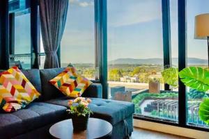 a blue couch in a living room with a large window at Skygarden On The Glen in Glen Waverley