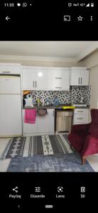 eine Küche mit weißen Schränken und einer roten Couch in der Unterkunft Avşa kiralık yazlık ev in Marmara