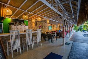 ein Restaurant mit Stühlen und eine Bar mit Weinflaschen in der Unterkunft Naturale Villas in Nusa Lembongan
