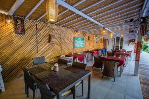 een restaurant met houten muren en tafels en stoelen bij Naturale Villas in Nusa Lembongan