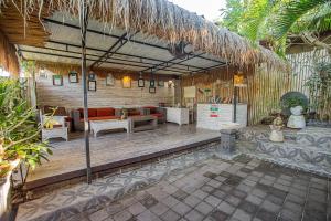 sala de estar al aire libre con sofá y sillas en Naturale Villas, en Nusa Lembongan