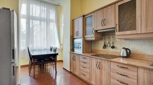 a kitchen with wooden cabinets and a table in it at Aphrodite Hotel Marianske Lazne in Mariánské Lázně