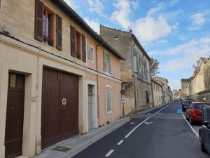 une rue vide avec des bâtiments et des voitures garés sur la route dans l'établissement Le logis de la tour, à Avignon