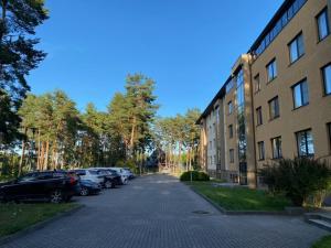 a parking lot with cars parked next to a building at Roja apartment Baltic in Roja